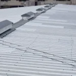 Close up of a white metal roof in broad daylight.