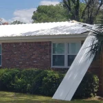 Residential single story home with newly installed white metal roof.