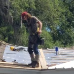 Man working on top of a roof under construction.